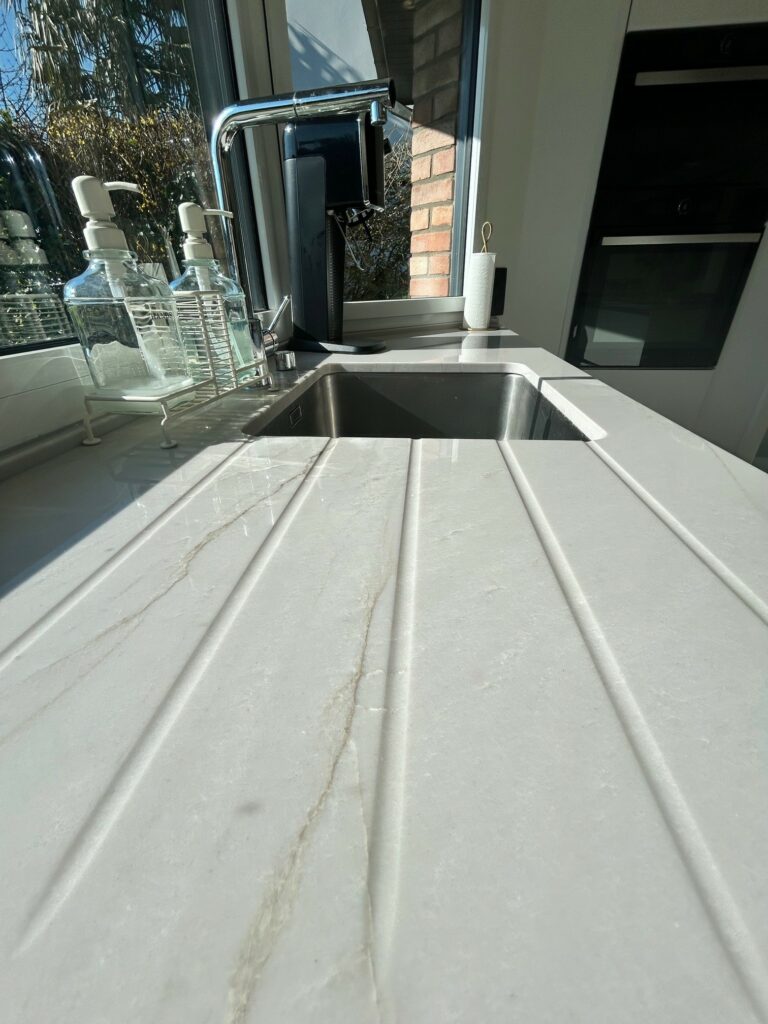 Aménagement d’une cuisine sur mesure – modèle First snaidero meubles laqués blancs, etffet bois plan en quartzite naturel. TRIADE Bailleul Flandres Nord Belgique